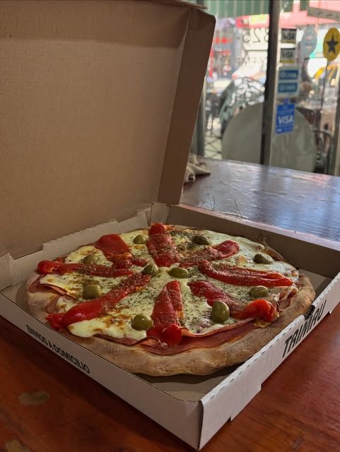 Pizza con morrones, jamón y aceitunas en caja